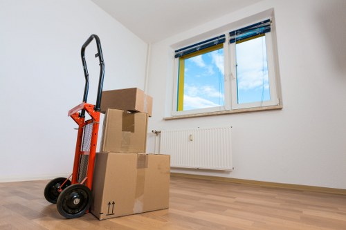 Removalists carrying furniture through a Brixton flat entrance